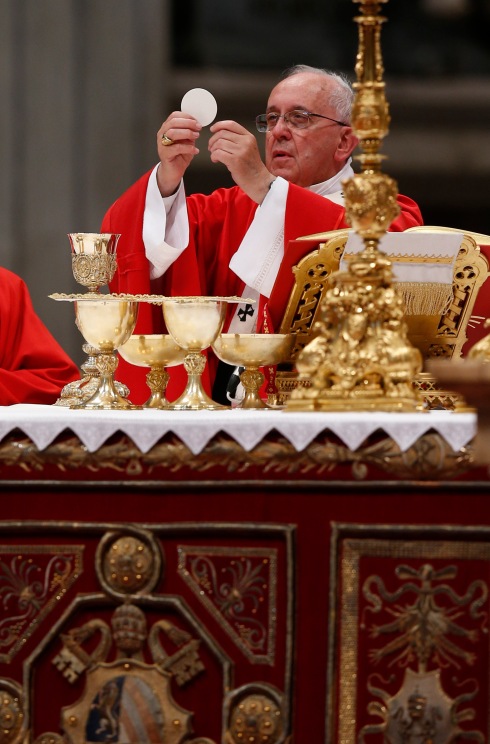 Pope Francis elevates Eucharist during Mass of Sts. Peter and Paul in St. Peter's Basilica at Vatican