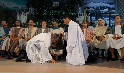 PRIEST WASHES FEET OF MAN DRESSED AS APOSTLE ON HOLY THURSDAY AT PANAMA CHURCH